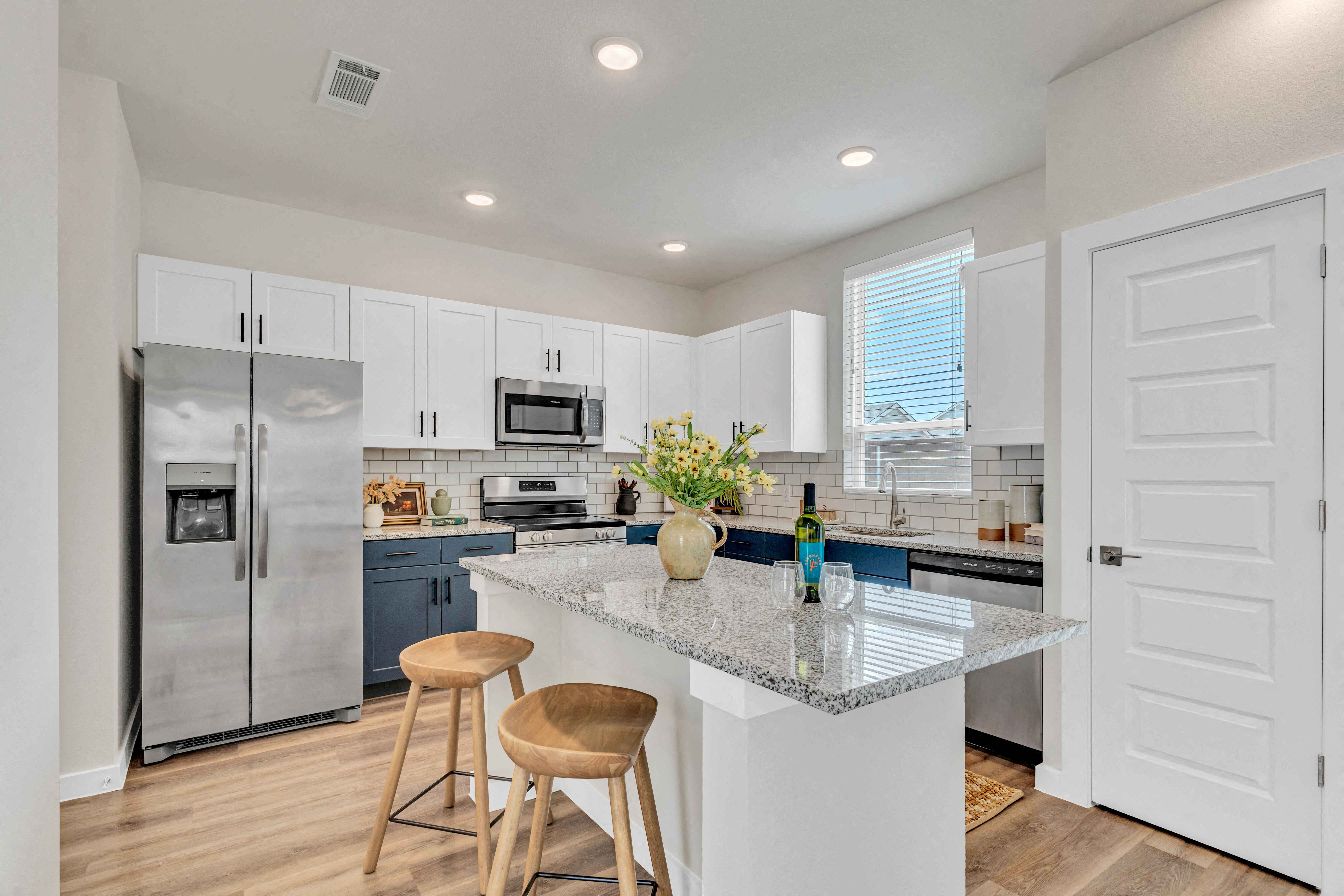 an open kitchen with a island with two stools